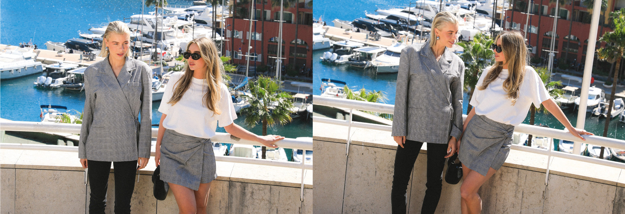 Twee vrouwen op een balkon met uitzicht op een drukke marina vol zeilboten.